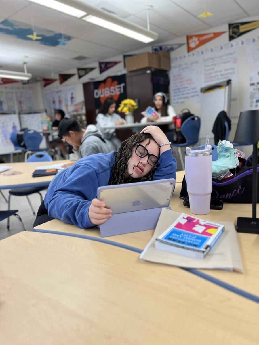 A student takes a brief nap during her first period class after a long night of dance rehearsal and studying.