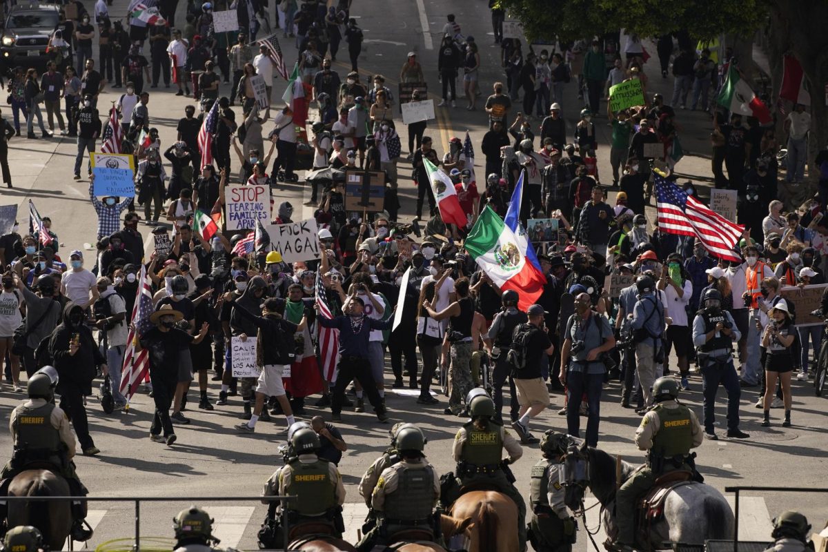 Demonstrators display Mexican and U.S. flags in front of mounted police at a protest against U.S. President Donald Trump's policies and federal immigration sweeps during a No Kings Day demonstration in Los Angeles, California, U.S., June 14, 2025.  REUTERS/David Ryder