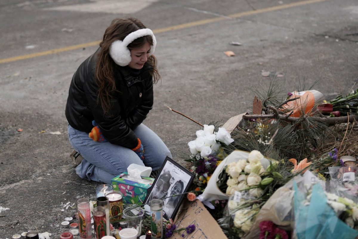 A person reacts at a makeshift memorial at the site where a man identified as Alex Pretti was fatally shot by federal immigration agents trying to detain him, in Minneapolis, Minnesota, U.S., January 25, 2026. REUTERS/Tim Evans