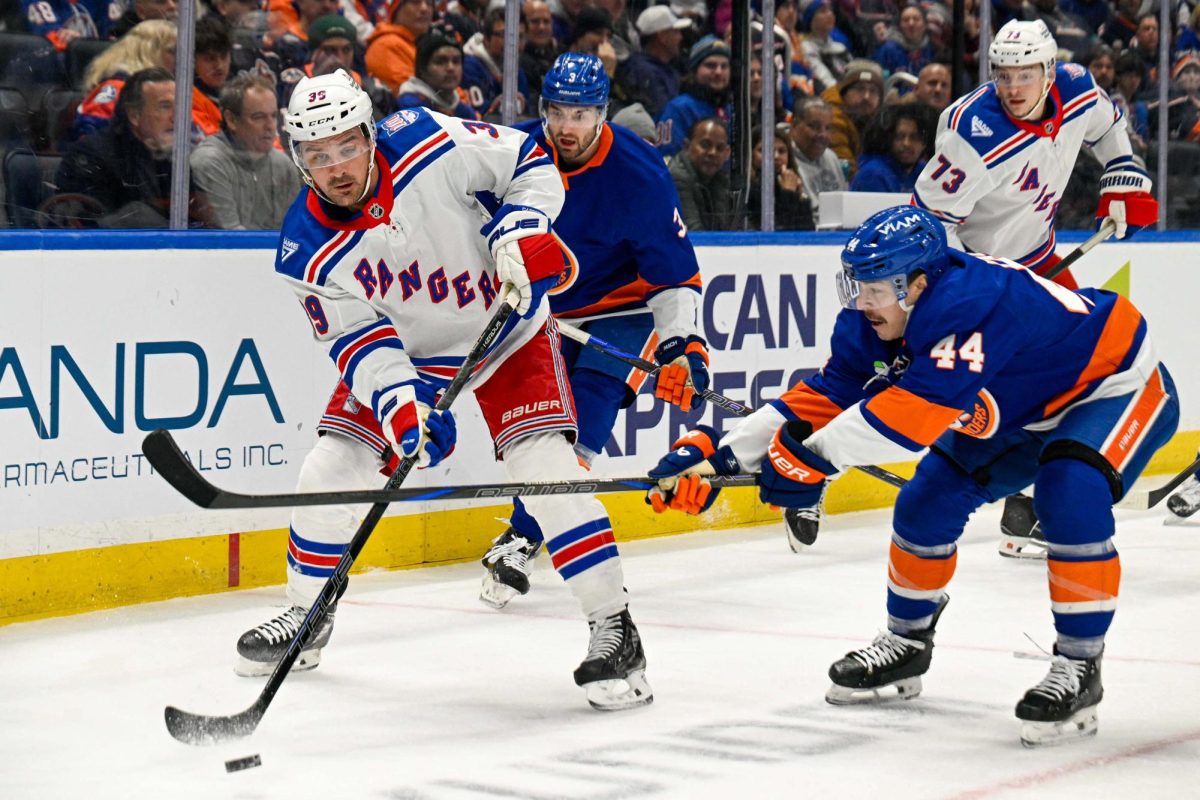 Jan 28, 2026; Elmont, New York, USA;  New York Rangers center Sam Carrick (39) passes the puck defended by New York Islanders center Jean-Gabriel Pageau (44) during the first period at UBS Arena. Mandatory Credit: Dennis Schneidler-Imagn Images