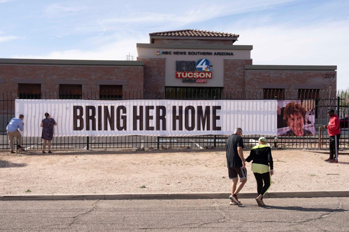 Well-wishers sign a banner that reads "Bring her home" and shows a photo of Nancy Guthrie, U.S. television journalist Savannah Guthrie's abducted elderly mother, at the KVOA newsroom, where Savannah worked earlier in her career, in Tucson, Arizona, U.S., February 12, 2026.  REUTERS/Rebecca Noble
