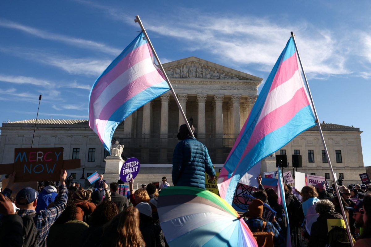 Demonstrators carry a transgender flags outside the U.S. Supreme Court, on the day justices are expected to hear oral arguments in two cases concerning efforts to enforce Republican-backed state laws banning transgender athletes from female sports teams at public schools, in Washington, D.C., U.S., January 13, 2026. REUTERS/Kevin Lamarque