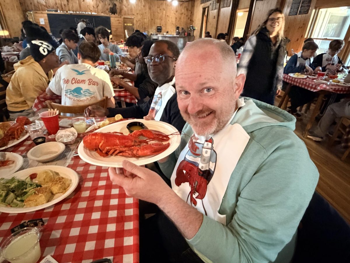 Dr. Tonissen holding up a plate of lobster at New England Music Camp.